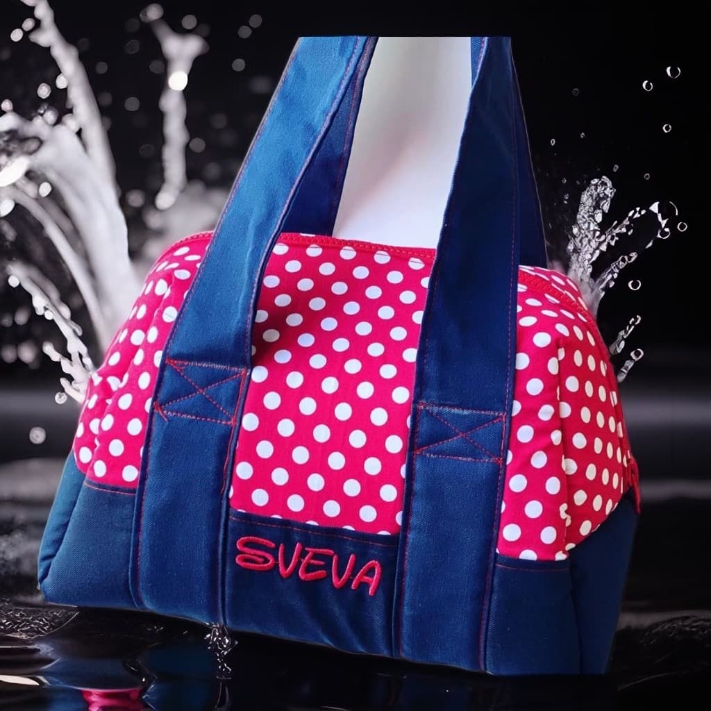 Borsa rosa a pois bianchi con base blu e nome Sveva ricamato tra spruzzi.